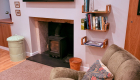 A comfortable chairby the wood burning stove in the lounge area